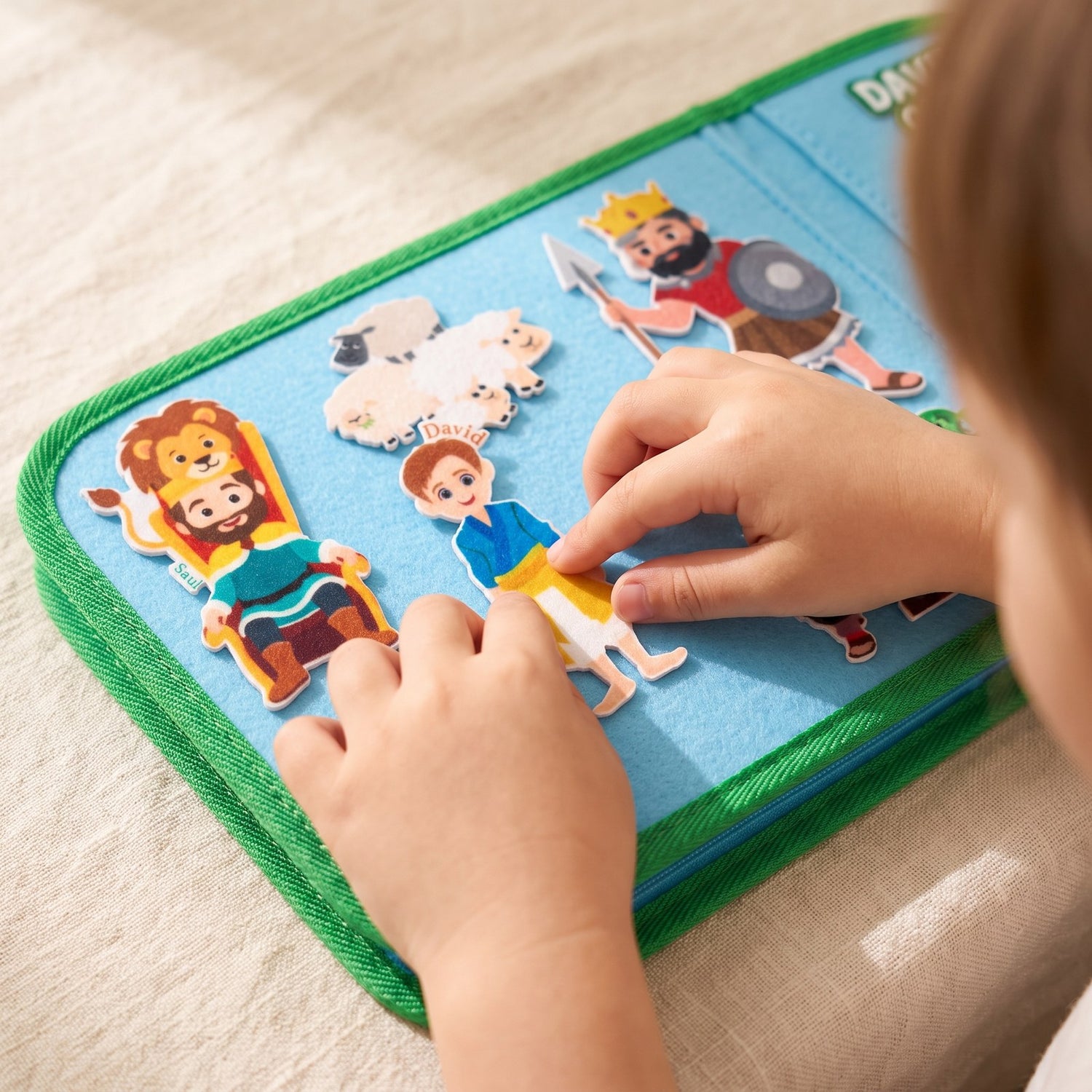 Close-up of a child's hands pressing a felt Bible character onto the felt board