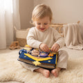 Toddler sitting on a cream rug with the handmade navy felt nativity quiet book open on their lap